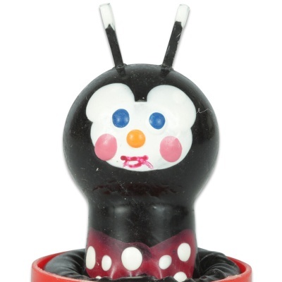 Brinquedo de plástico com rosto pintado e base vermelha