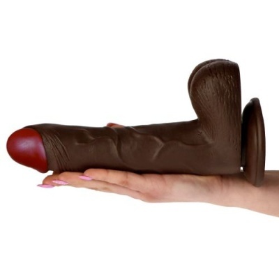 Dildo realista castanho escuro com cabeça vermelha sobre mão feminina