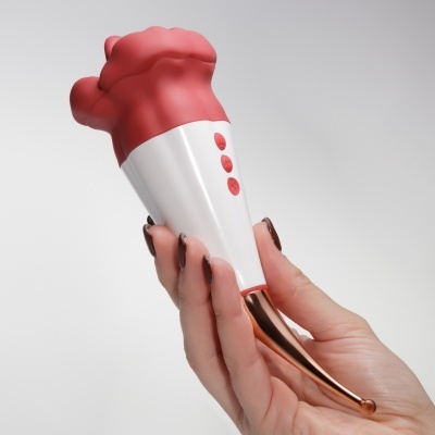 Produto manual com parte superior vermelha em silicone, corpo branco com botões e cabo metálico curvo de cobre, segurado por uma mão.