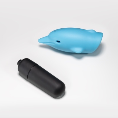 Golfinho azul de plástico e objeto preto cilíndrico