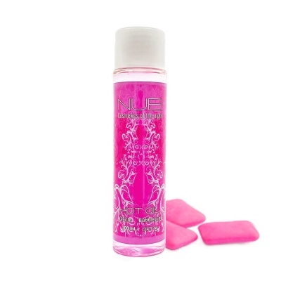 Frasco de óleo cor-de-rosa com rotulagem e pastilhas de chiclete cor-de-rosa