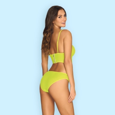 Mulher de costas com lingerie amarelo fluorescente em fundo azul claro.