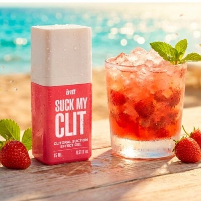 Gel íntimo Suck My Clit Intt vermelho e branco ao lado de morangos e bebida com gelo e hortelã sobre mesa de madeira