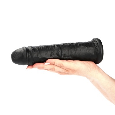 Dildo preto com textura realista e base larga segurado por uma mão