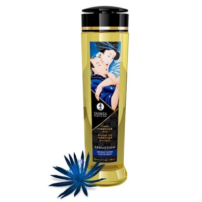 Frasco de óleo de massagem Shunga com rótulo azul e flor azul ao lado