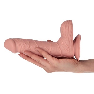 Dildo de tonalidade pele com base de ventosa segura por uma mão