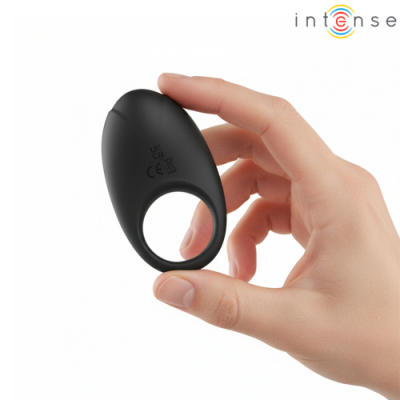 Anel vibratório preto oval em mão contra fundo branco