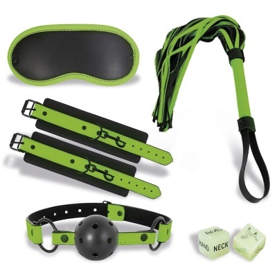 Acessórios BDSM verdes e pretos com venda, algemas, chicote e bola amordaçadora com dados de posições.