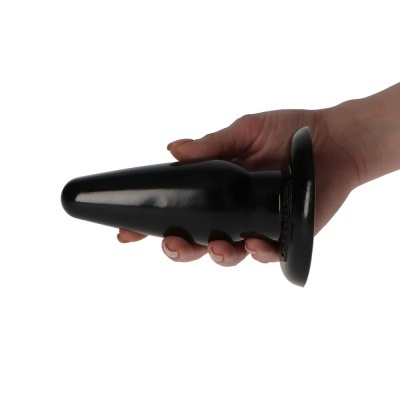 Mão segurando plugue anal preto cónico com base larga