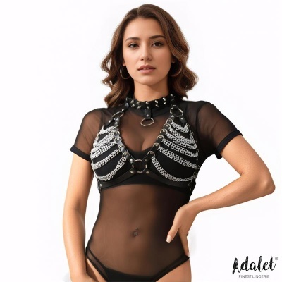 Mulher com body preto semi-transparente com colete de couro sintético e correntes prateadas em fundo branco