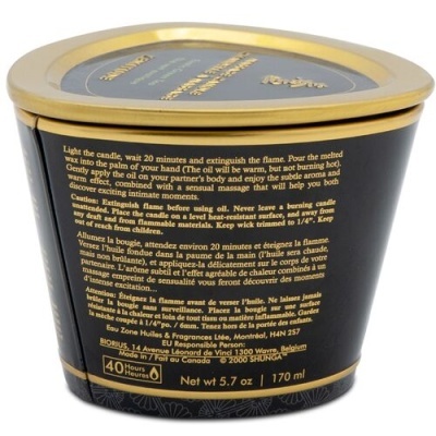 Vela perfumada num recipiente triangular com tampa dourada e texto no rótulo