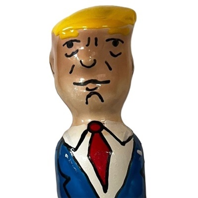 Boneco de cerâmica com cabelo amarelo, fato azul e gravata vermelha