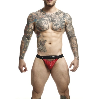 Homem atlético com tatuagens usando cueca jockstrap vermelha e preta
