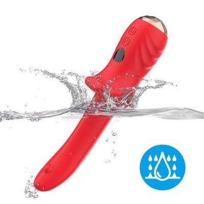 Massageador vermelho submerso em água com três botões visíveis