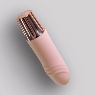Aparelho vibrador cor-de-rosa com tampa dourada e botão de sorriso
