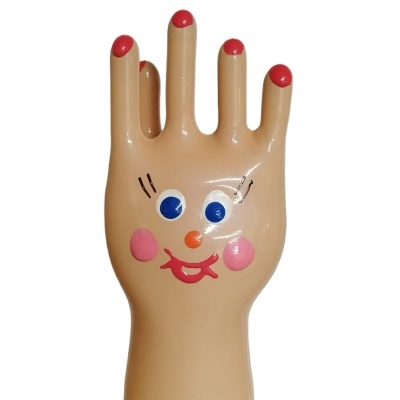 Mão de plástico cor pele com rosto desenhado e unhas vermelhas