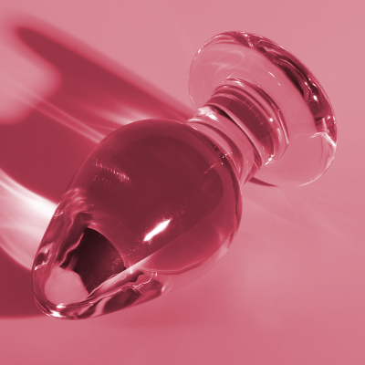 Plug anal de vidro transparente sobre fundo rosa