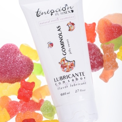 Frasco branco de lubrificante com sabor rodeado de rebuçados de gelatina coloridos