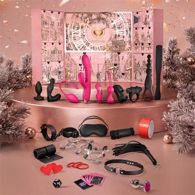Conjunto de brinquedos sexuais e acessórios variados em silicone e metal em frente a calendário de advento rosa.