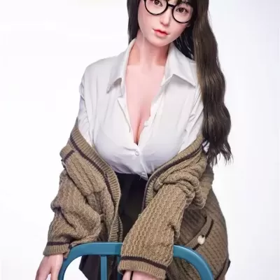 Boneca realista com camisa branca, camisola bege e óculos redondos sobre cadeira azul