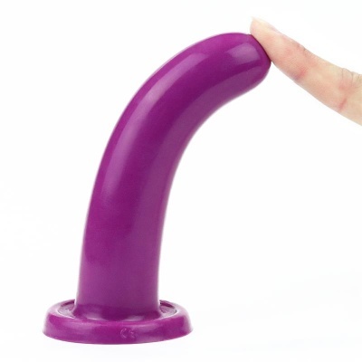 Objeto curvado de silicone roxo com base larga e dedo indicador tocando a ponta.