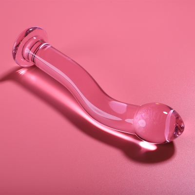 Objeto em vidro transparente curvado sobre fundo rosa
