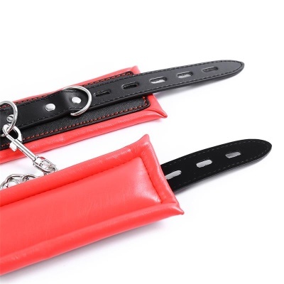 Par de algemas acolchoadas em vermelho com tiras pretas e fivelas prateadas