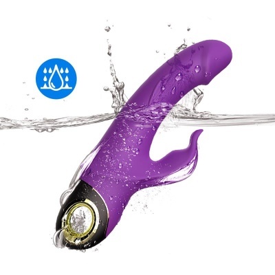 Vibrador roxo resistente à água com detalhes em preto e dourado imerso em água