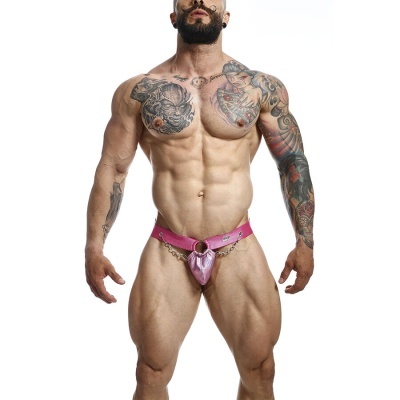 Homem musculado com tanga rosa e tatuagens em fundo branco