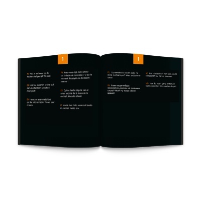 Livro aberto com páginas pretas e texto em várias línguas coloridas