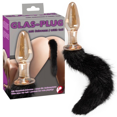 Plug anal de vidro com cauda preta ao lado da embalagem.