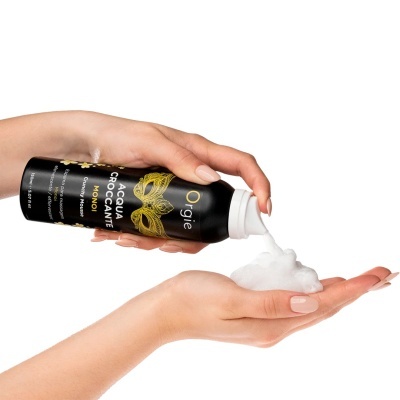 Frasco preto de espuma para massagem Orgie Acqua Croccante Monoi a ser espumado em mão clara