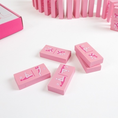Peças de dominó cor-de-rosa com desenhos de posições, feitas de madeira