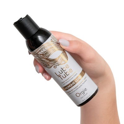 Frasco de lubrificante Lube Tube com rótulo branco e dourado segurado por mão