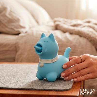 Figura decorativa azul em forma de gato com coleira branca numa mesa de madeira
