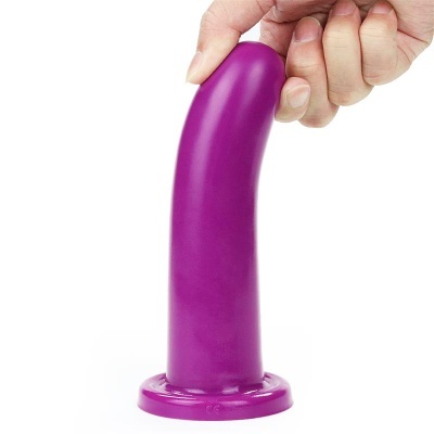 Objeto cilíndrico roxo de silicone com base, segurado por mão, fundo branco