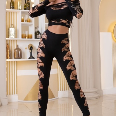 Mulher a usar conjunto preto de top e leggings com recortes em padrão de rede e sapatos de salto pretos