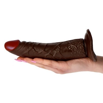 Produto em tons castanhos e vermelhos segurado numa mão com unhas rosa claro