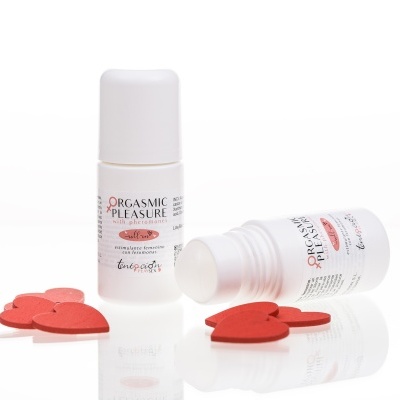 Frascos brancos de roll-on com etiquetas de estimulante feminino perto de corações vermelhos de madeira.