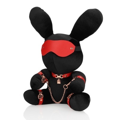 Boneco de pelúcia preto em forma de coelho com venda e algemas vermelhas