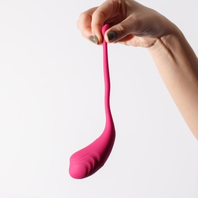 Mão segurando objeto rosa curvo