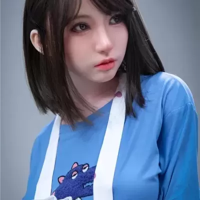 Boneca realista com camisa azul e avental branco com corações cor-de-rosa