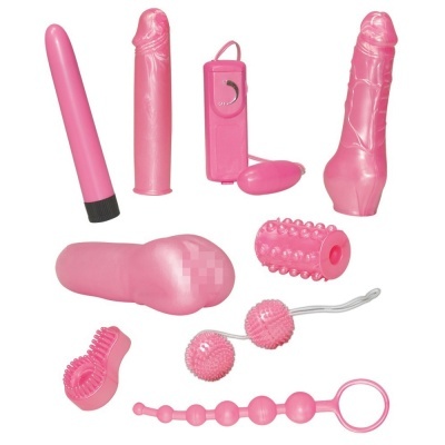 Conjunto de brinquedos sexuais cor-de-rosa variados sobre fundo branco