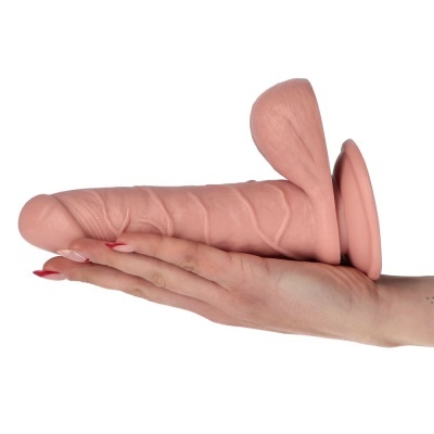 Dildo realista cor pele com base alargada e textura detalhada sobre mão.