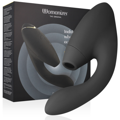 Produto preto curvo em silicone com orifício circular em frente a uma caixa preta Womanizer