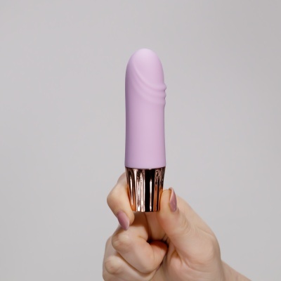 Produto rosa claro com base dourada sendo segurado por mão com unhas nude