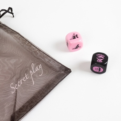 Dados eróticos cor-de-rosa e preto perto de saco de tecido transparente preto com texto Secret play