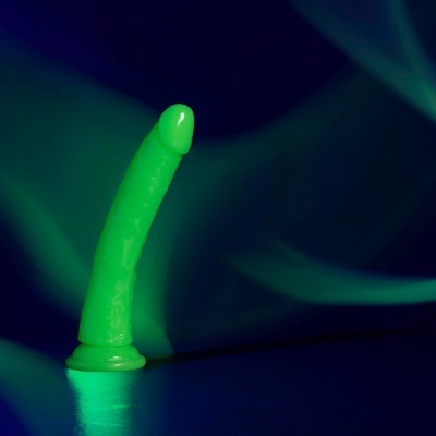 Dildo verde fluorescente em fundo escuro com luzes verdes suaves
