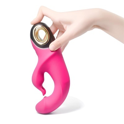Vibrador cor-de-rosa com detalhe dourado segurado por uma mão