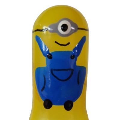Figura plástica amarela com olho único e jardineira azul